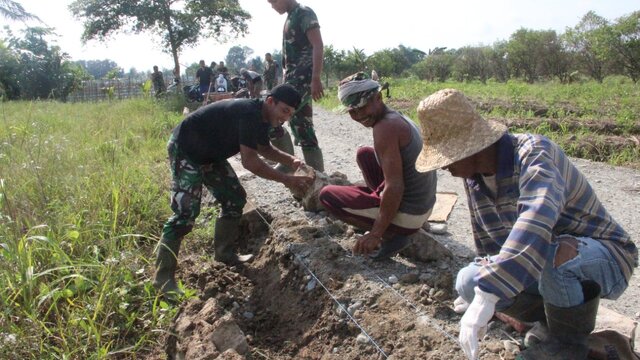 Satgas TMMD Bersama Warga Perbaiki Pondasi Batas Kanan Kiri Jalan