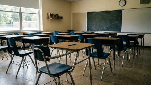 Ruang kelas kosong dengan deretan meja kursi sepi menggambarkan fenomena sekolah negeri kekurangan peminat tahun ajaran baru
