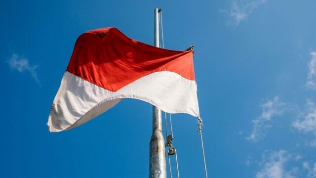 Bendera Merah Putih berkibar di tiang tinggi sesuai Aturan Kibarkan Bendera Merah Putih