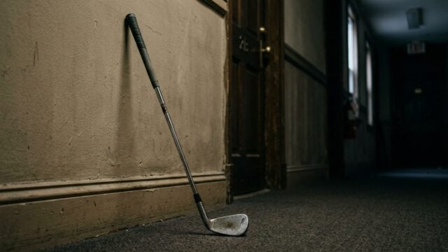 Peralatan golf milik atlet profesional di ruangan kosong